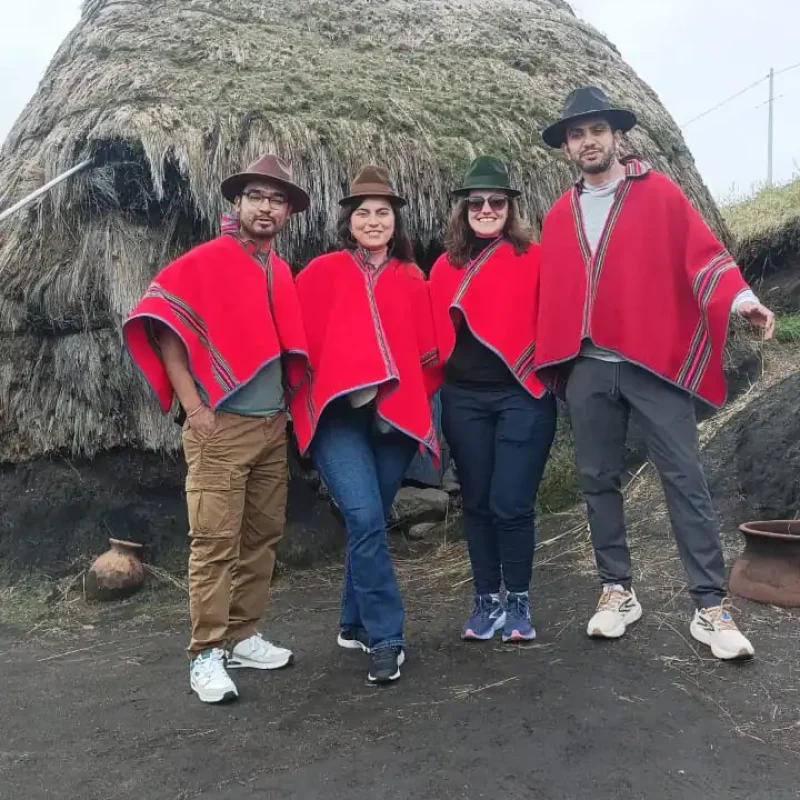 Local indigenous family smiling next to travelers during a cultural tour Ecuador