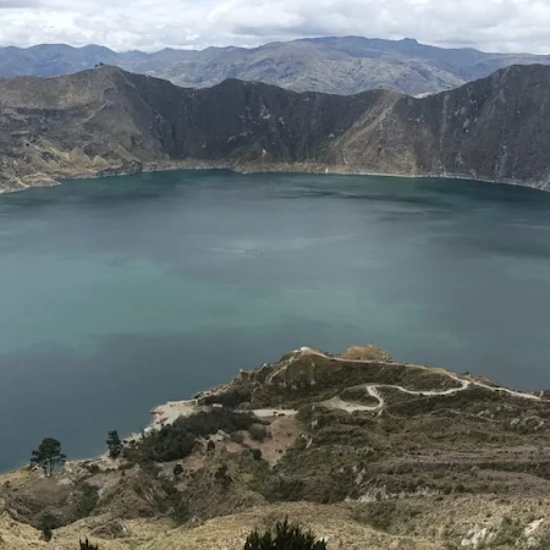 Travelers hiking down to the emerald waters of Quilotoa lagoon on a scenic tour Ecuador
