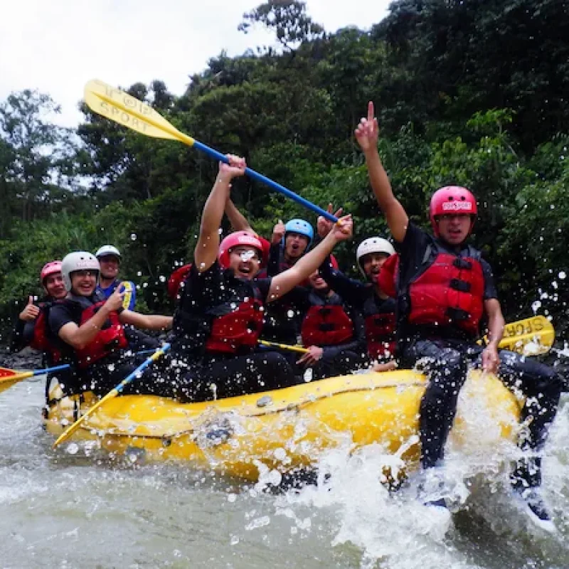 A group of tourists paddling in perfect synchronization during their rafting in baños ecuador tour