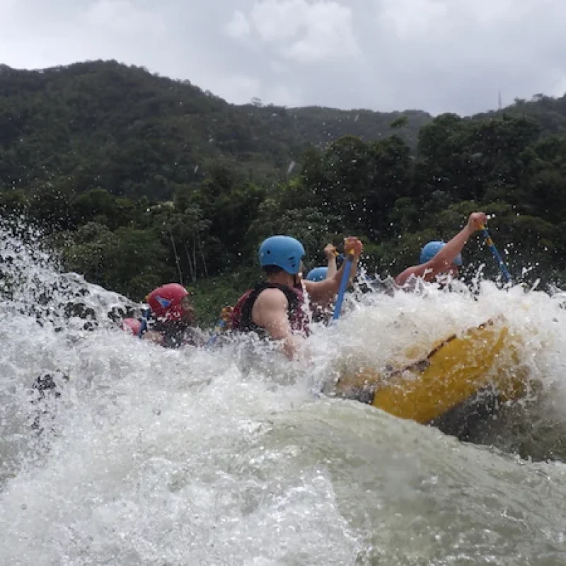 Adventurers paddling through intense class III and IV rapids during a rafting in baños ecuador tour
